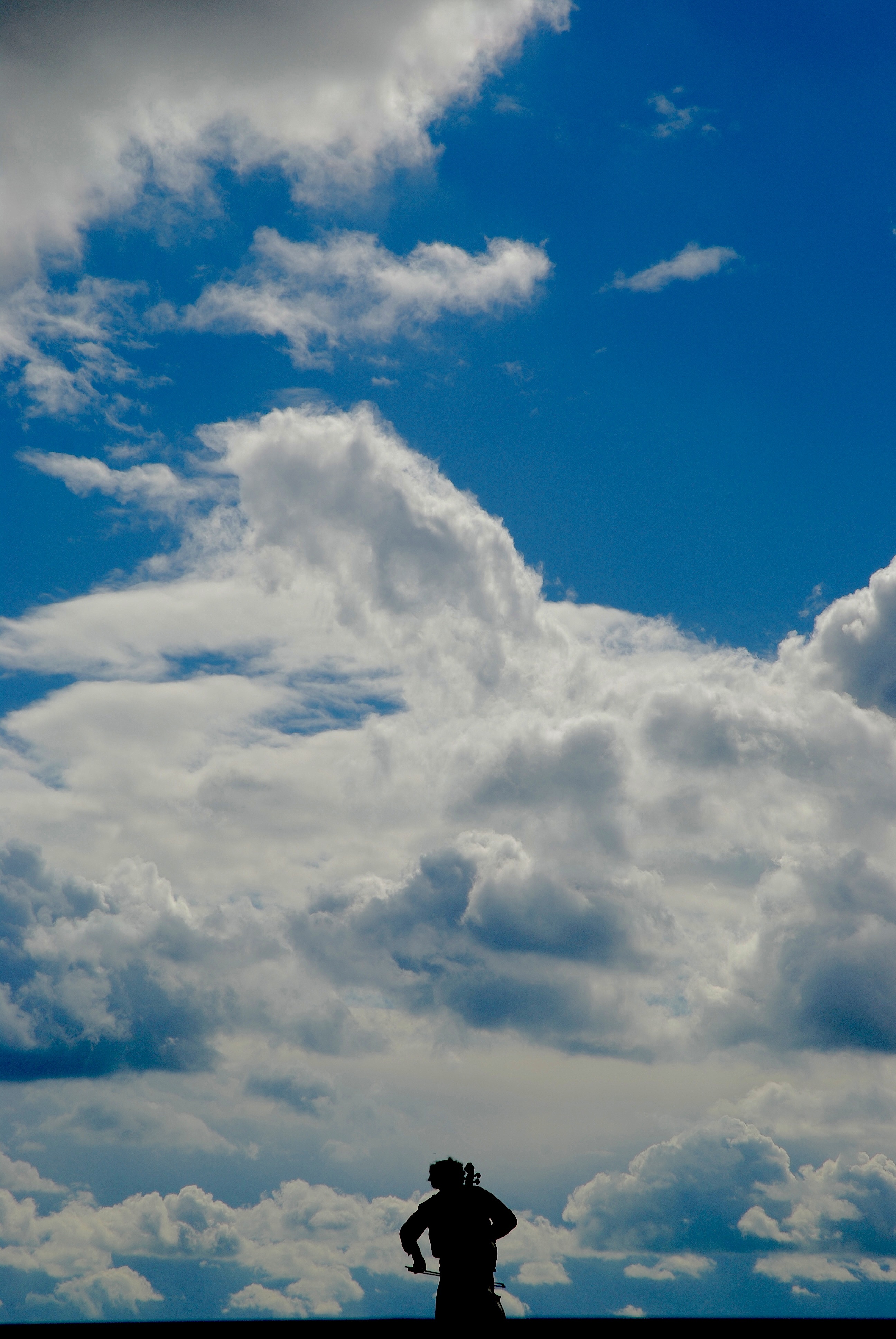 weiter Himmel, unten Mann mit Cello